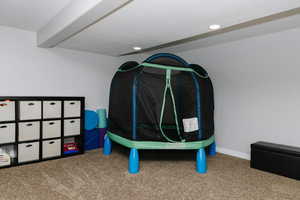 Recreation room featuring carpet floors and beamed ceiling