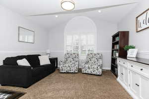 Living room featuring vaulted ceiling and light carpet