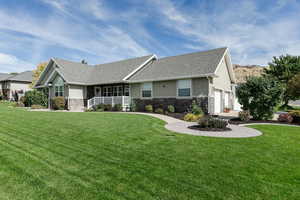 View of front of home with a front lawn, a garage, and covered porch