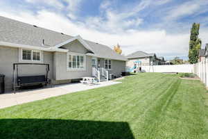 Back of house with a playground, a yard, and a patio