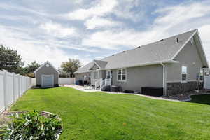 Back of property featuring a yard, central AC unit, and a patio area