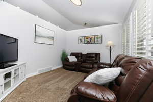 Living room with carpet, lofted ceiling, and ornamental molding