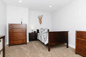 Bedroom featuring light colored carpet