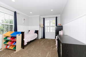 Bedroom with crown molding and carpet