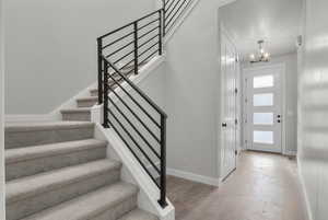 Entrance foyer featuring a chandelier, wood-type flooring, and a textured ceiling