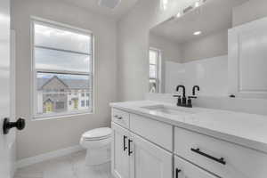 Bathroom with vanity, toilet, and a healthy amount of sunlight