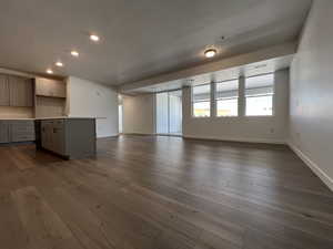 Unfurnished living room with dark wood-type flooring