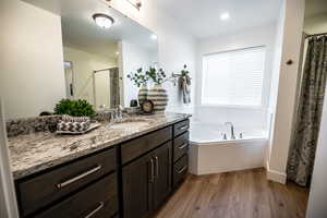 Bathroom with vanity, plus walk in shower, and hardwood / wood-style floors