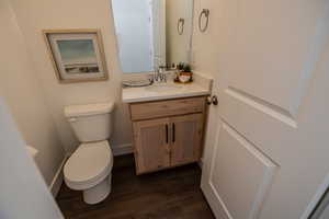 Bathroom featuring wood-type flooring, vanity, and toilet