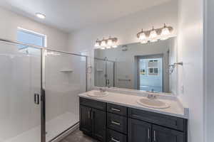 Bathroom featuring a shower with door and vanity