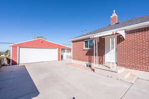 View of side of home featuring a garage and an outbuilding