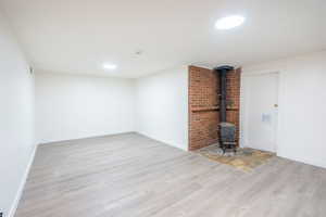 Unfurnished living room featuring light hardwood / wood-style floors and a wood stove