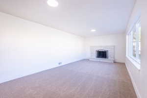 Unfurnished living room with carpet floors and a fireplace