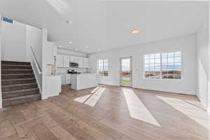 Unfurnished living room with light hardwood / wood-style floors and sink