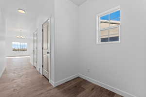 Corridor featuring hardwood / wood-style flooring and a notable chandelier