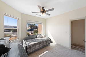 Bedroom with multiple windows, hardwood / wood-style floors, and ceiling fan