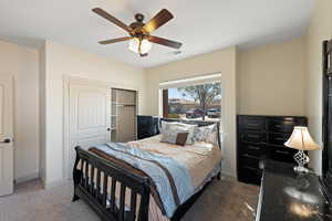 Carpeted bedroom with a closet and ceiling fan