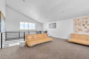 Sitting room with high vaulted ceiling and carpet floors