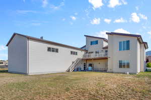 Back of house with a lawn and a patio