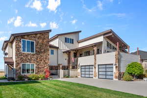 View of front of property featuring a front yard and a garage