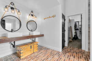 Bathroom featuring wood walls and sink