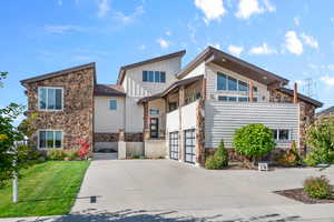 View of front of property with a front yard and a garage