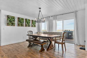 Dining space featuring a chandelier, hardwood / wood-style floors, and wooden ceiling