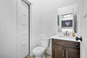 Bathroom featuring hardwood / wood-style flooring, vanity, and toilet