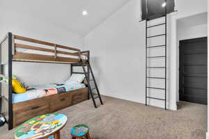 Bedroom featuring light carpet and vaulted ceiling