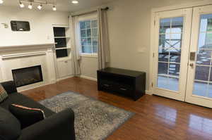 Living room with french doors and dark hardwood / wood-style flooring