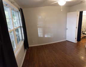 Unfurnished room with ceiling fan and dark wood-type flooring