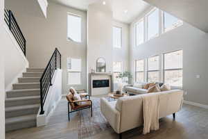 Living room featuring light hardwood / wood-style floors and a towering ceiling