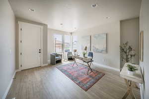 Interior space featuring light wood-type flooring and a textured ceiling