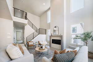 Living room featuring a towering ceiling and a healthy amount of sunlight