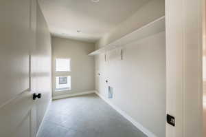 Laundry area with tile patterned floors, hookup for a washing machine, and hookup for an electric dryer