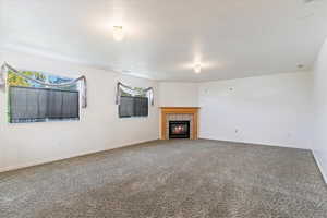 Unfurnished Family room featuring carpet floors and a fireplace