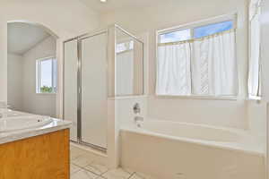 Master Bathroom featuring vanity, separate shower and tub, and vaulted ceiling