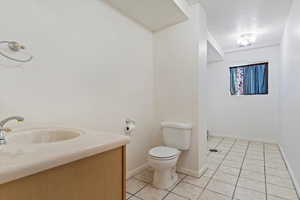 Bathroom with vanity, toilet, and tile patterned floors