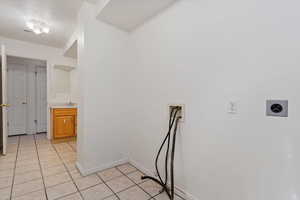 Washroom with washer hookup, light tile patterned floors, and sink