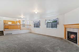 Unfurnished Family room featuring a fireplace and carpet flooring