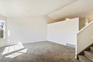 Formal Living Room featuring vaulted ceiling and carpet flooring