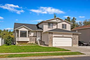 View of front property with a front lawn and a extra wide garage