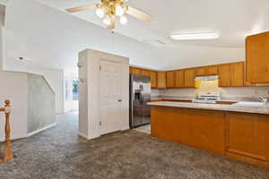 Kitchen featuring kitchen peninsula semi formal dining, light carpet, white range oven, ceiling fan, and stainless steel fridge