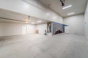 Garage featuring strapped water heater and a garage door opener