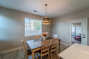 Dining space with hardwood / wood-style flooring