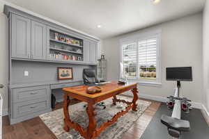 Home office with dark wood-type flooring