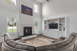 Living room with a high ceiling, wood walls, and dark hardwood / wood-style floors