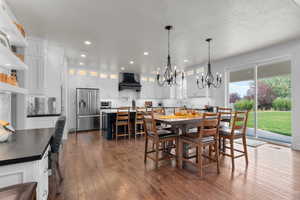 Dining space with a notable chandelier, a textured ceiling, and dark hardwood / wood-style flooring