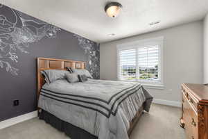 Bedroom featuring a textured ceiling and light colored carpet