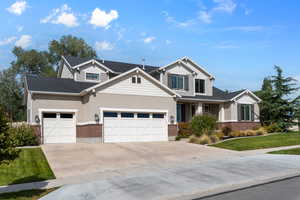 Craftsman-style home featuring a garage and a front lawn